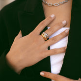 Main portant une bague bombée bicolore dorée et argentée