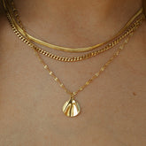 Collier triple rang doré à maille fine et pendentif coquillage porté
