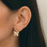 Boucle papillon dorée à zircons portée à l&