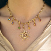 Collier à charms soleil et gouttes de pierres colorées porté au cou