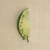 Boucles dorées à zircons verts posées sur un citron vert