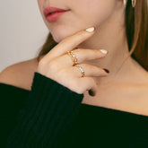 Femme portant des bagues fines dorées à zircons