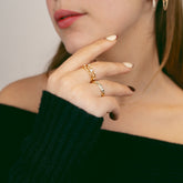 Femme portant des bagues fines dorées serties de zircons